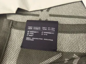 Detail view of the woven jacquard blanket product specification tag, showing size and care guide.