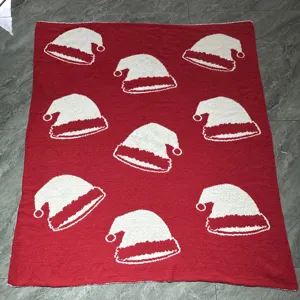 Couverture de Noël rouge avec motifs de bonnet de Père Noël blanc, jeté doux pour les fêtes.