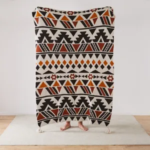 Detailed bohemian knitted jacquard blanket detail showing ethnic geometric patterns and tassels.