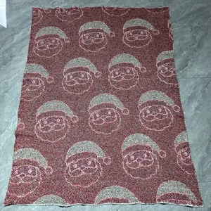 Couverture tricotée de Noël avec motif classique de père Noël pour une ambiance festive.