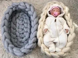 Handgefertigtes klobiges Strick-Babynest und Fotografie-Requisitenkorb, gemütliche Detailansicht.