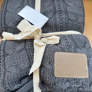 Dark grey knitted cable throw blanket close up detail texture soft cozy home decor item