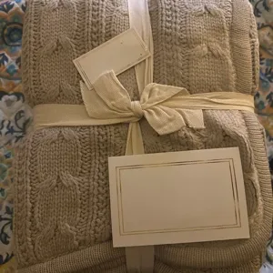 Cable knit blanket detail, folded design with ribbon tie and decorative blank cards.