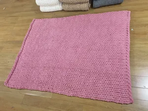 Rosa grob gestrickte Decke Detailansicht, weiche Chenille Wohndecke fuer Sofa und Schlafzimmer.