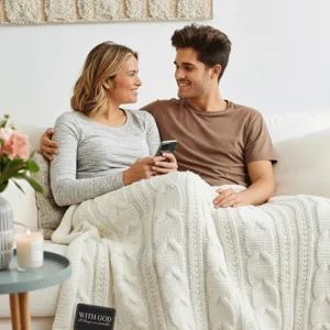 Cozy white cable knit blanket detail showcasing soft woven texture draped over a comfortable couch.