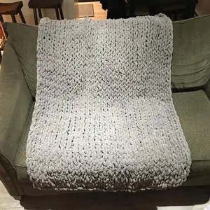 Graue grobe Strick-Chenille-Decke Detailansicht, gemütliche Wohnzimmer Sofadekoration.