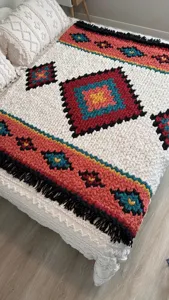 Boho style handmade chunky knit blanket with geometric rhombus pattern and tassels for cozy home decor.