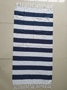 Dettaglio di telo mare turco a righe blu e bianche con eleganti frange decorative.
