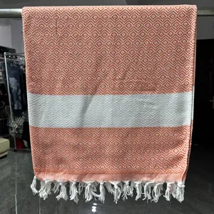 Detailweergave geweven jacquard katoenen strandlaken met oranje ruitpatroon en franjes.
