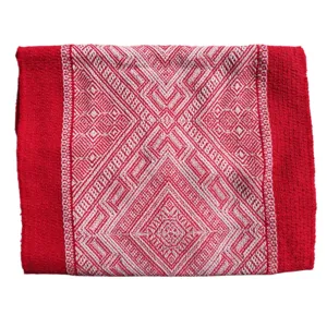 Gros plan sur les détails du chemin de table tissé géométrique rouge et blanc avec texture.