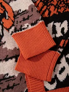 Primo piano della manica del maglione lavorato a maglia, trama accogliente e calda.