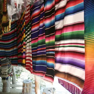 Detailed view of colorful Mexican striped fabric, vibrant bohemian rainbow cotton textile.