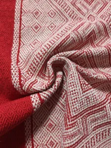 Détail de tissu de chemin de table tissé rouge et blanc, texture de lin géométrique.
