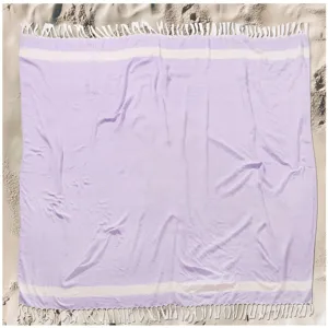 Detailed view of a lavender cotton beach towel featuring white stripes and nice decorative tassels.