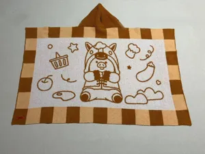 Detail view of the cute cartoon pig patterned hooded plush blanket, soft texture, cozy home.