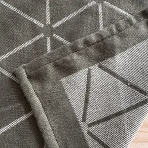 Dark grey woven jacquard throw blanket with modern geometric pattern close-up view product