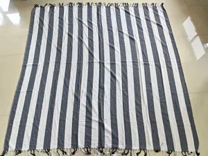 Close-up view of the black and white striped cotton beach towel showcasing fringe details.
