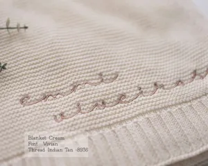 Custom embroidered knit baby blanket in cream color, soft cotton fabric for warm cozy use.