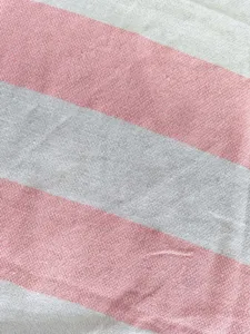 Close-up detail of the Turkish striped beach towel fabric texture in pink and white color.