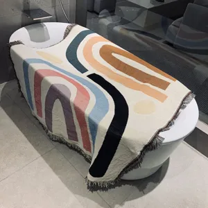 Nordic style knitted throw blanket with geometric rainbow pattern and fringe detail for decor.