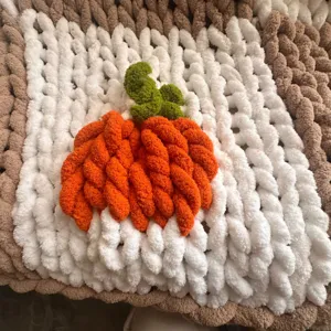 Couverture tricotée à la main en fil chenille épais avec motif de citrouille et carreaux.