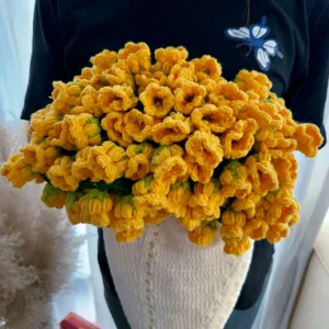 Handmade crochet lily of the valley flower blanket, yellow acrylic floral throw blanket detail.