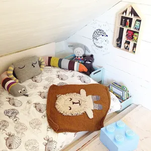 Detailansicht der niedlichen handgemachten Strick-Löwendecke im gemütlichen Kinderzimmer.
