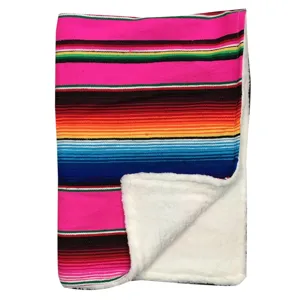 Detail shot of a colorful Mexican striped baby blanket with cozy white sherpa fleece lining.
