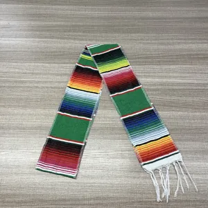 Close-up of traditional Mexican serape table runner with vibrant woven stripes and white fringe.