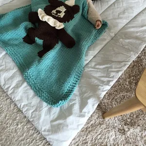 Handgemachte grobe Strick-Babydecke mit niedlichem 3D-Cartoon-Monster-Detailansicht.