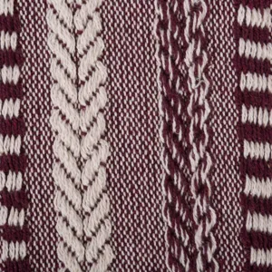 Gros plan détaillé de tissu de couverture jacquard avec motif de torsades bordeaux et beige.