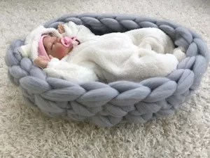 Gemütliches graues grob gestricktes Babynest Detail, handgemachte Neugeborenen Requisite.