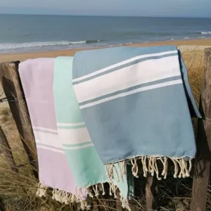 Vista detallada de toalla de playa turca a rayas de colores con flecos en la playa.