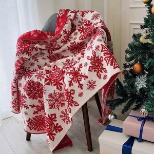 Festive red and white knitted jacquard blanket with snowflake pattern for holiday home decor.