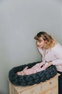 Gemütliches Neugeborenen-Fotografie-Detail des dicken Strick-Babynests in tollem Grau.
