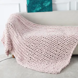 Close-up detail of soft pink chunky chenille knit blanket showing cozy texture details.