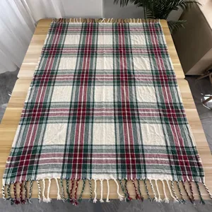 Klassieke rood-groene ruitjesdeken met franjes, gezellige bankhoes en campingmat.