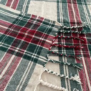 Detail van chenille ruit plaid deken met zachte geweven textuur en decoratieve franjes.