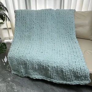 Chunky knit blanket detail shot, mint green chenille throw for cozy living room sofa decor.