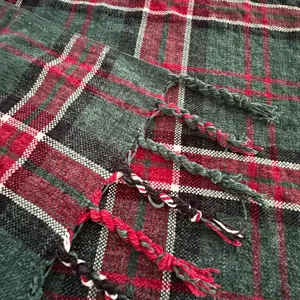 Detailopname van zachte chenille plaid met ruitjes en franjes, gezellige textuur voor bank.