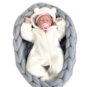 Handgemachte grob gestrickte Babynestchen-Foto-Requisite mit süsser Reborn-Puppe für Neugeborene.