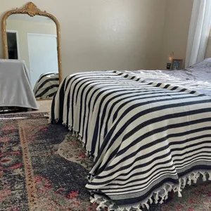 Cozy black and white striped woven throw blanket detail, showcasing soft fringe texture.