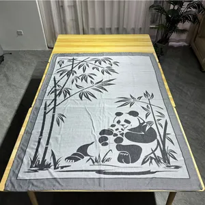 Gewebtes Jacquard-Decken-Detail mit klarem Panda- und Bambusmuster auf dem Tisch.