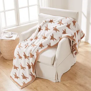 Cozy plush fleece throw blanket with brown star pattern on soft white knit for home decor.