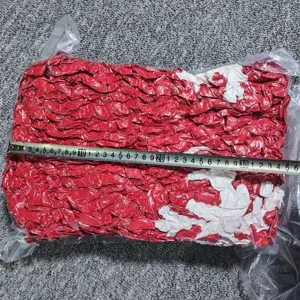 Vue détaillée d'une couverture en tricot épais rouge et blanc emballée sous vide.