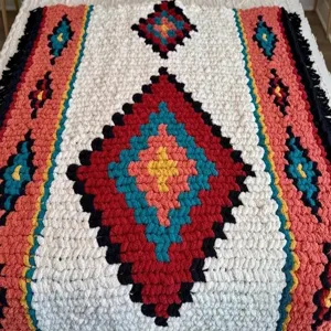 Chunky knit chenille blanket detail shot featuring ethnic diamond pattern and cozy bohemian texture.