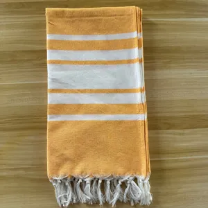 Orange-weiße gestreifte türkische Strandtuch mit Fransen für Sommerurlaub und Reise.