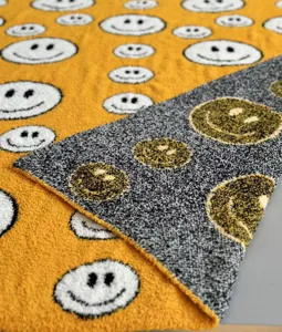 Soft knit smiley face jacquard plush blanket detail showcasing textured pattern