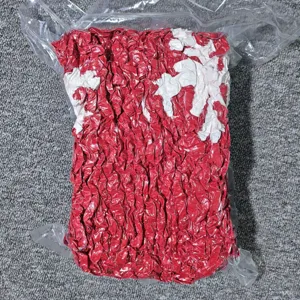 Vue détaillée d'une couverture en fil grossier rouge et blanc compressée sous vide.