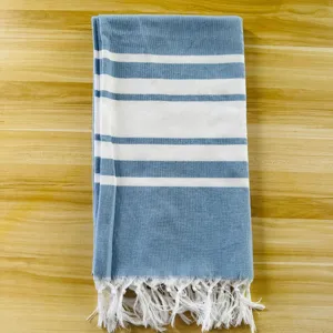 Nahaufnahme des blau-weiß gestreiften türkischen Strandtuchs mit Fransen und Stoff.